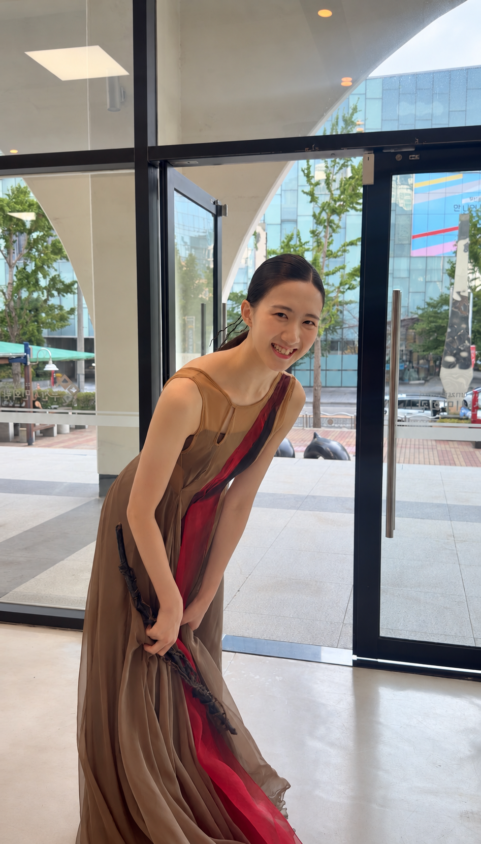 International Dance Grand Prix 현장에서 무대 의상을 입고 웃고 있는 학생